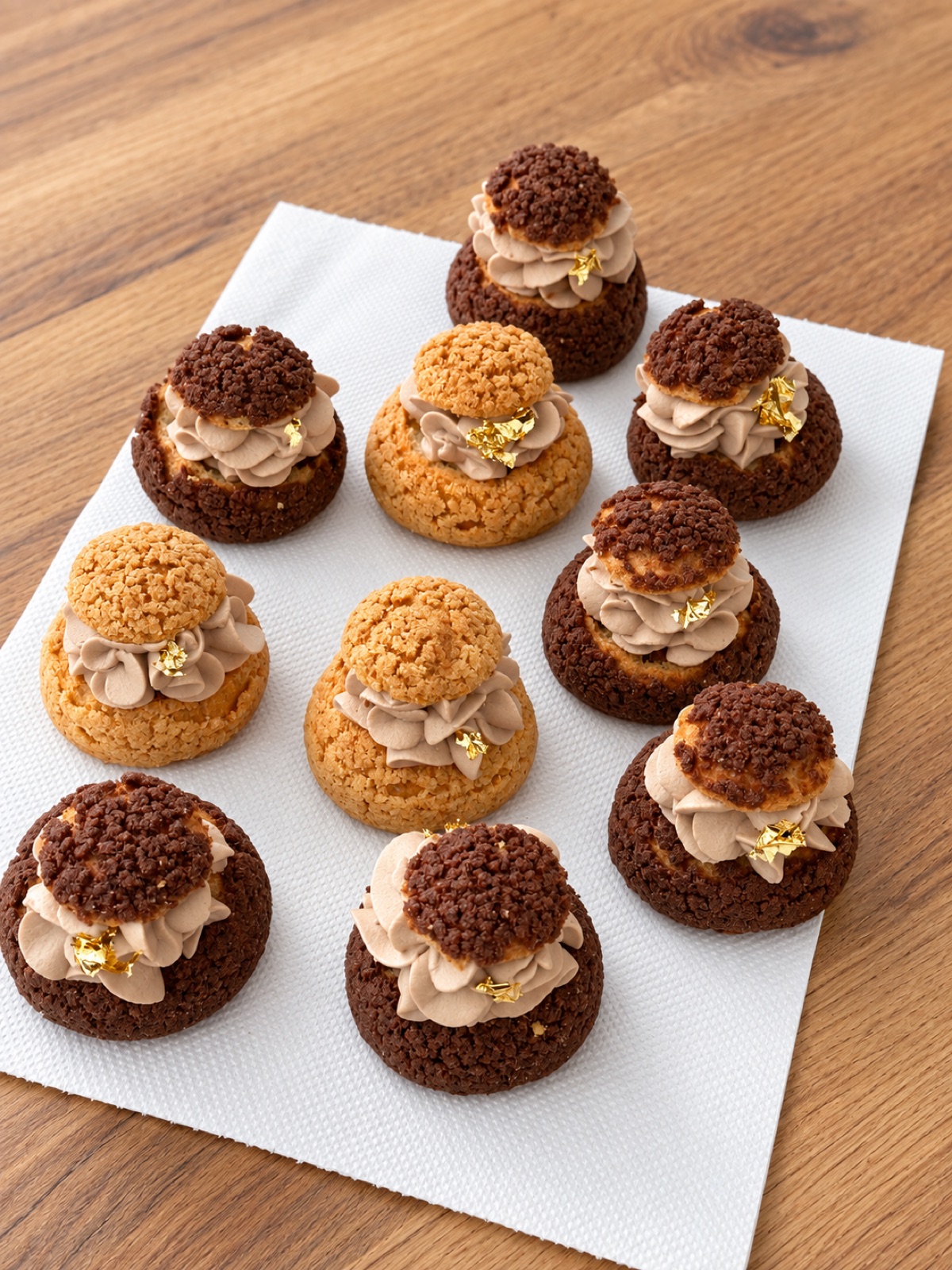 Choux buns with craquelin tops, chocolate cream and a fleck of gold leaf